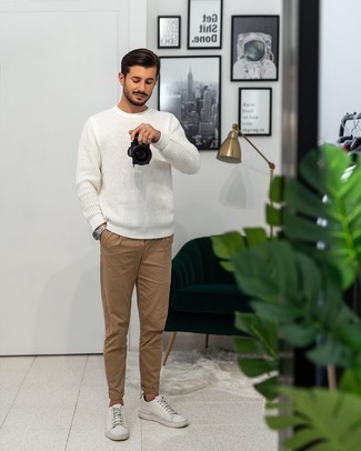 White Crew-neck Sweater Casual Outfits For Men: This pairing of a white crew-neck sweater and khaki chinos is on the casual side but will guarantee that you look on-trend and incredibly dapper. Introduce a pair of white leather low top sneakers to the mix to keep the ensemble fresh.