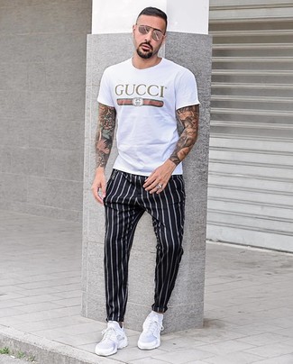 Black Vertical Striped Chinos Outfits: A white print crew-neck t-shirt and black vertical striped chinos are a go-to off-duty combo for many trendsetting gents. For a more casual spin, complement this getup with a pair of white athletic shoes.