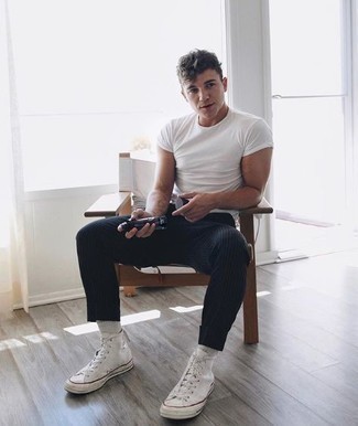Black Vertical Striped Chinos Outfits: If you're on a mission for a relaxed casual but also dapper ensemble, go for a white crew-neck t-shirt and black vertical striped chinos. Rounding off with white canvas high top sneakers is a simple way to inject a laid-back touch into this look.