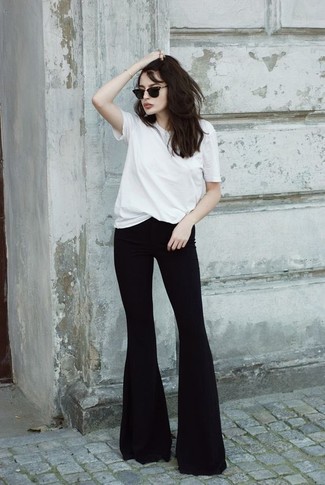 Black Flare Jeans Outfits: Extremely stylish, this combination of a white crew-neck t-shirt and black flare jeans delivers variety.