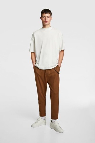 Brown Chinos Hot Weather Outfits: This look with a white crew-neck t-shirt and brown chinos isn't super hard to put together and is easy to adapt throughout the day. The whole ensemble comes together when you complement your outfit with a pair of white canvas low top sneakers.