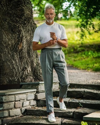 White Canvas Low Top Sneakers Smart Casual Outfits For Men After 50: A white crew-neck t-shirt and grey dress pants worn together are a wonderful match. Puzzled as to how to finish? Complete this look with a pair of white canvas low top sneakers for a more laid-back aesthetic. So if you need fashion tips on how to dress in your 50s, this combo is perfect.