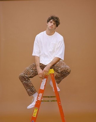 White Crew-neck T-shirt with Khaki Leopard Chinos Outfits: Dress in a white crew-neck t-shirt and khaki leopard chinos and you'll be prepared for whatever this day throws at you. A pair of white canvas low top sneakers integrates really well within a great deal of ensembles.
