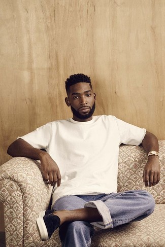 Tinie Tempah wearing White Crew-neck T-shirt, Light Blue Jeans, Black Suede Slip-on Sneakers, Gold Watch