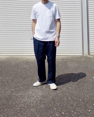 1200+ Casual Hot Weather Outfits For Men: Effortlessly blurring the line between sharp and off-duty, this pairing of a white crew-neck t-shirt and navy chinos is likely to become your go-to. Our favorite of a countless number of ways to complete this outfit is white canvas low top sneakers.