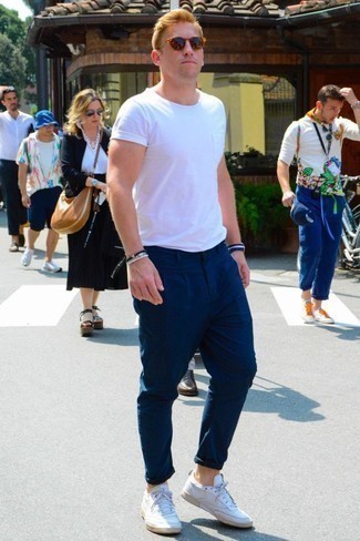 White Low Top Sneakers Outfits For Men: This combo of a white crew-neck t-shirt and navy chinos is impeccably stylish and yet it looks casual and ready for anything. Add white low top sneakers to the equation et voila, the outfit is complete.