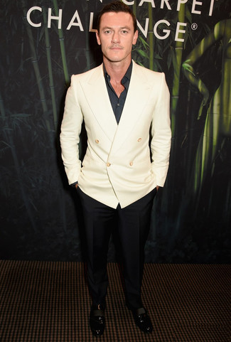 Luke Evans wearing White Double Breasted Blazer, Black Long Sleeve Shirt, Black Dress Pants, Black Leather Loafers