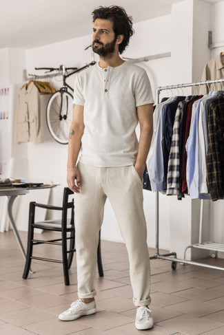 White and Black Henley Shirt Outfits For Men: The versatility of a white and black henley shirt and beige chinos guarantees they will stay on heavy rotation in your menswear collection. White canvas low top sneakers are a good pick to round off this outfit.
