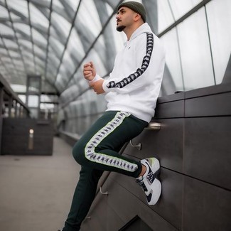 Dark Green Sweatpants Outfits For Men: A white hoodie and dark green sweatpants are a laid-back combination that every modern gentleman should have in his menswear arsenal. White and black athletic shoes look amazing here.
