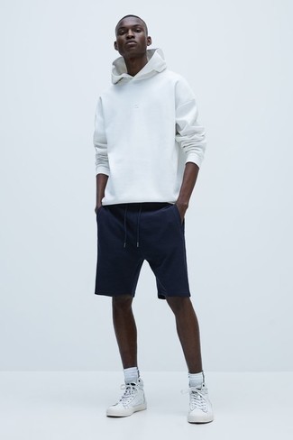 White Hoodie Outfits For Men: Reach for a white hoodie and navy sports shorts for a relaxed getup. Let your sartorial expertise truly shine by rounding off your outfit with a pair of white leather high top sneakers.