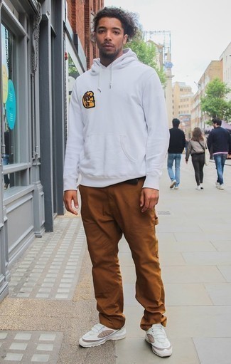 White Print Hoodie Outfits For Men: This pairing of a white print hoodie and tobacco chinos is super easy to pull together and so comfortable to work as well! Get a little creative on the shoe front and dial down this getup by wearing a pair of white athletic shoes.
