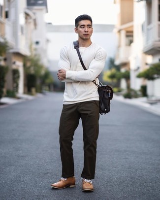 Black Leather Messenger Bag Outfits: A white long sleeve henley shirt and a black leather messenger bag are bona fide staples if you're planning a casual wardrobe that matches up to the highest sartorial standards. Introduce a pair of tan leather derby shoes to your look for a major style boost.