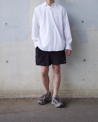 121 Relaxed Outfits For Men: A white long sleeve shirt and black sports shorts are the kind of a no-brainer off-duty getup that you need when you have no time to dress up. Rounding off with grey athletic shoes is a surefire way to bring a dash of stylish nonchalance to this look.
