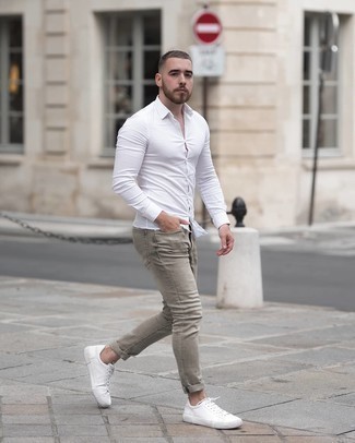 Grey Skinny Jeans Outfits For Men: Look on-trend yet functional by opting for a white long sleeve shirt and grey skinny jeans. Add a pair of white leather low top sneakers to your outfit for maximum effect.