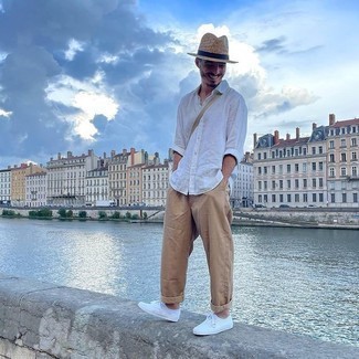 Tan Straw Hat Outfits For Men: A white long sleeve shirt and a tan straw hat are the perfect base for a ton of combinations. Balance out your outfit with a sleeker kind of footwear, such as this pair of white canvas low top sneakers.