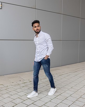 Navy Ripped Skinny Jeans Outfits For Men: For a casual ensemble with a contemporary take, reach for a white long sleeve shirt and navy ripped skinny jeans. Give a different twist to this getup by finishing with white and black leather low top sneakers.