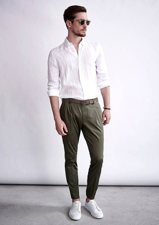 Dark Green Dress Pants Outfits For Men: Parade your sophisticated self in a white linen long sleeve shirt and dark green dress pants. Complement your outfit with a pair of white leather low top sneakers to easily up the wow factor of your getup.