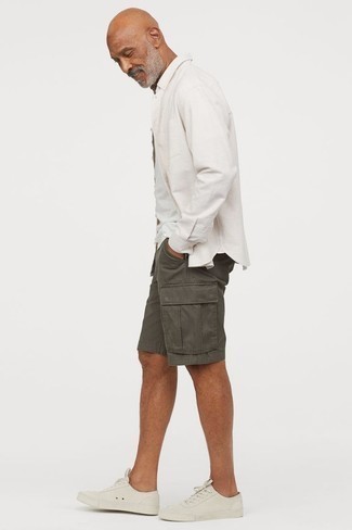 Low Top Sneakers Outfits For Men: This casual pairing of a white long sleeve shirt and charcoal shorts is super easy to pull together in no time flat, helping you look awesome and ready for anything without spending a ton of time digging through your wardrobe. The whole look comes together if you add low top sneakers to this getup.