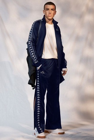 Blue Track Suit Outfits For Men: For a casual ensemble, consider teaming a blue track suit with a white long sleeve t-shirt — these two items fit really good together. A pair of white leather low top sneakers will give a different twist to an otherwise everyday outfit.