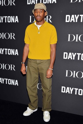 Tyler, the Creator wearing Beige Bucket Hat, White Leather Low Top Sneakers, Olive Chinos, Mustard Polo