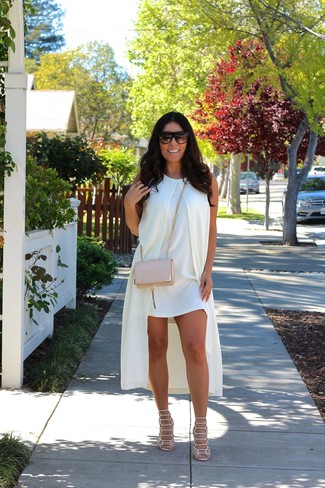 Beige Leather Crossbody Bag Outfits: This seriously stylish laid-back look is ever-so-simple: a white shift dress and a beige leather crossbody bag. Add beige leather heeled sandals to the mix to instantly rev up the wow factor of this getup.