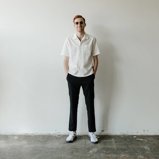 White and Navy Canvas Low Top Sneakers Outfits For Men: Such pieces as a white short sleeve shirt and black chinos are an easy way to introduce extra cool into your current casual rotation. Look at how great this outfit is finished off with a pair of white and navy canvas low top sneakers.