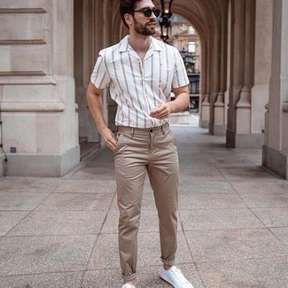 White Vertical Striped Short Sleeve Shirt Outfits For Men: A white vertical striped short sleeve shirt and khaki chinos are a combination that every modern guy should have in his casual wardrobe. A pair of white canvas low top sneakers makes your look whole.