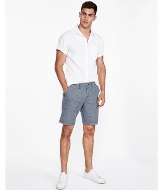 Navy Shorts Outfits For Men: A white short sleeve shirt and navy shorts are both versatile menswear staples that will integrate nicely within your off-duty styling lineup. Add a pair of white leather low top sneakers to the mix et voila, the ensemble is complete.