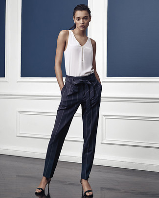 Navy Vertical Striped Tapered Pants Outfits For Women: Wear a white silk sleeveless top with navy vertical striped tapered pants for an effortless kind of refinement. Go ahead and complement this outfit with a pair of black leather heeled sandals for a hint of class.