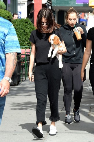 Selena Gomez wearing Black Sunglasses, White Leather Slip-on Sneakers, Black Fringe Dress Pants, Black Cropped Top