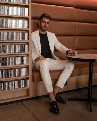White Suit Outfits: A white suit and a black crew-neck t-shirt will add serious style to your daily lineup. You know how to play it up: dark brown leather tassel loafers.