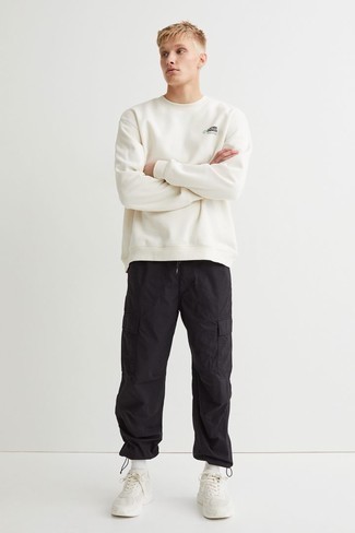 White and Navy Athletic Shoes Outfits For Men: A white sweatshirt and black cargo pants are a combination that every modern guy should have in his wardrobe. Take an otherwise sober look in a more informal direction with white and navy athletic shoes.