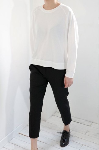 White Sweatshirt Outfits For Women: A white sweatshirt and black tapered pants are a savvy combo worth integrating into your off-duty routine. Avoid looking too casual by finishing with a pair of black leather oxford shoes.