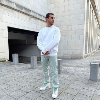 White Sweatshirt Outfits For Men: This look with a white sweatshirt and mint sweatpants isn't so hard to score and is easy to adapt. If you're clueless about how to round off, a pair of white and green canvas high top sneakers is a tested option.