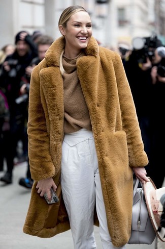 Candice Swanepoel wearing Grey Leather Tote Bag, White Tapered Pants, Brown Knit Oversized Sweater, Tan Fur Coat
