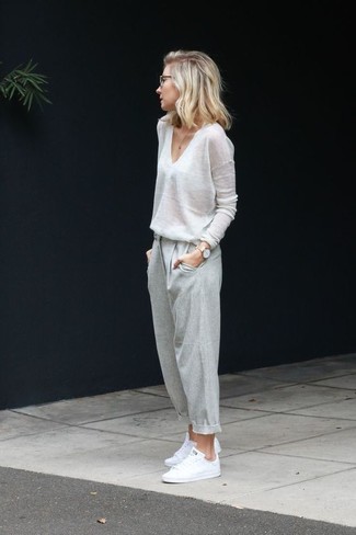 Plimsolls Outfits For Women: A white v-neck sweater and grey sweatpants combined together are a covetable look for those who love ultra-cool outfits. The whole ensemble comes together really well if you add a pair of plimsolls.
