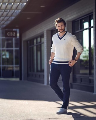 White V-neck Sweater Outfits For Men: This seriously stylish look is super simple: a white v-neck sweater and navy chinos. Light blue canvas low top sneakers will bring a carefree feel to your outfit.