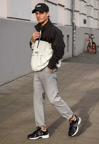 Black Windbreaker Outfits For Men: You can look amazing without really trying by opting for a black windbreaker and grey chinos. Unimpressed with this getup? Enter black and white athletic shoes to spice things up.