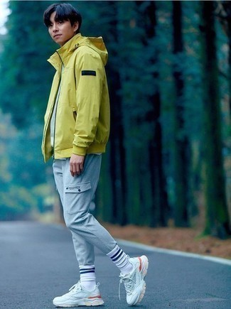Grey Cargo Pants Outfits: Loving how well a yellow windbreaker works with grey cargo pants. Feeling creative today? Spice up your outfit by slipping into a pair of white athletic shoes.