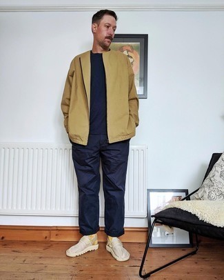 Tan Windbreaker Outfits For Men: A tan windbreaker and navy chinos are the kind of a fail-safe casual getup that you so terribly need when you have no time to dress up. Our favorite of an infinite number of ways to round off this look is beige canvas slip-on sneakers.