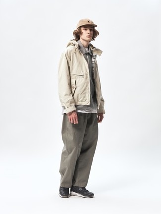 Men's Outfits 2022: A beige windbreaker and olive chinos are absolute menswear essentials if you're putting together an off-duty wardrobe that matches up to the highest sartorial standards. Enter a pair of black and white athletic shoes into the equation to inject an element of stylish effortlessness into this outfit.