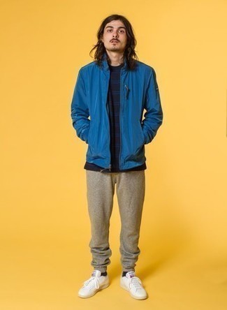 Blue Windbreaker Outfits For Men: Why not go for a blue windbreaker and tan sweatpants? These pieces are super practical and look cool paired together. Introduce a pair of white canvas low top sneakers to the mix et voila, this look is complete.