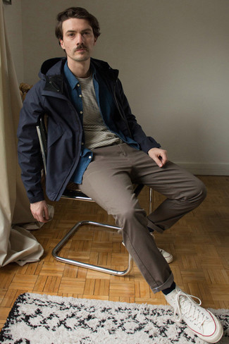Navy Windbreaker Outfits For Men: Marry a navy windbreaker with brown chinos if you want to look casual and cool without trying too hard. Send an otherwise mostly classic getup down a more casual path by finishing with white canvas high top sneakers.