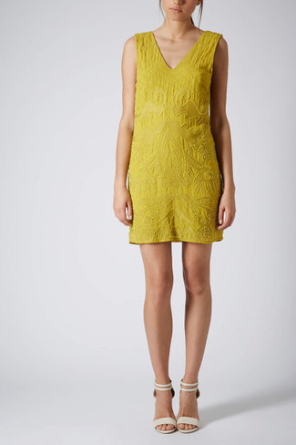 For an outfit that's super easy but can be smartened up or dressed down in a ton of different ways, rock a yellow beaded shift dress. A pair of white leather heeled sandals will be the perfect addition to this look.