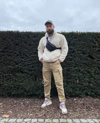 Fanny Pack Outfits For Men: For the style that looks as cool as it can get, choose a white fleece zip sweater and a fanny pack. All you need now is a pair of multi colored athletic shoes to complement this outfit.