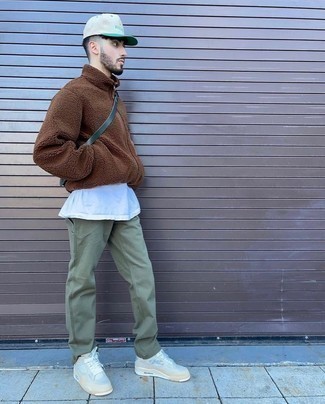 Brown Fleece Zip Sweater Outfits For Men: This pairing of a brown fleece zip sweater and olive chinos is super easy to achieve and so comfortable to work as well! For a more relaxed take, why not introduce white leather low top sneakers to this getup?