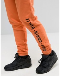 Asos Skinny Joggers With Gothic Text In Orange